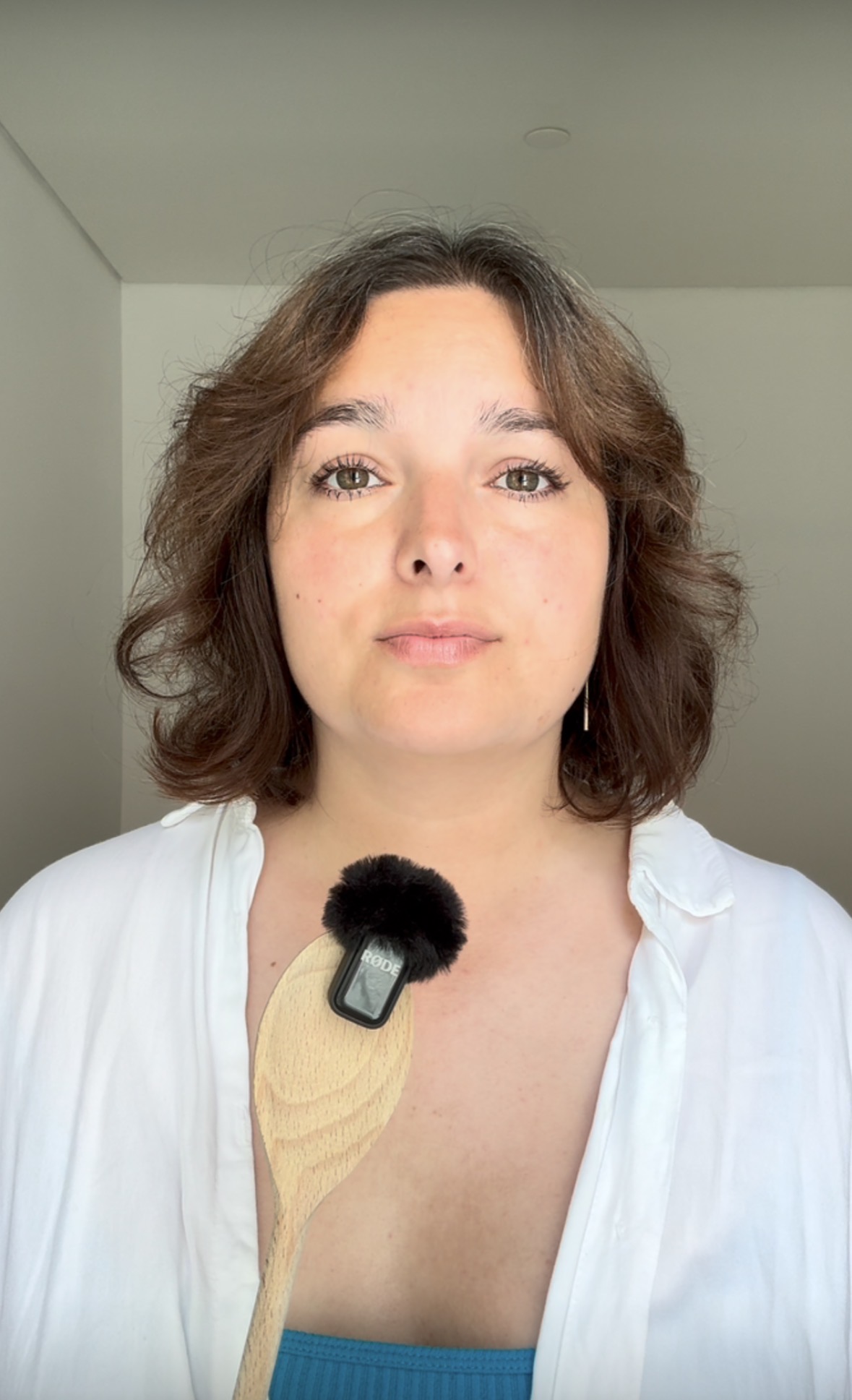 Natascha Pavia heute, mit Mikrofon, ruhig in die Kamera blickend.